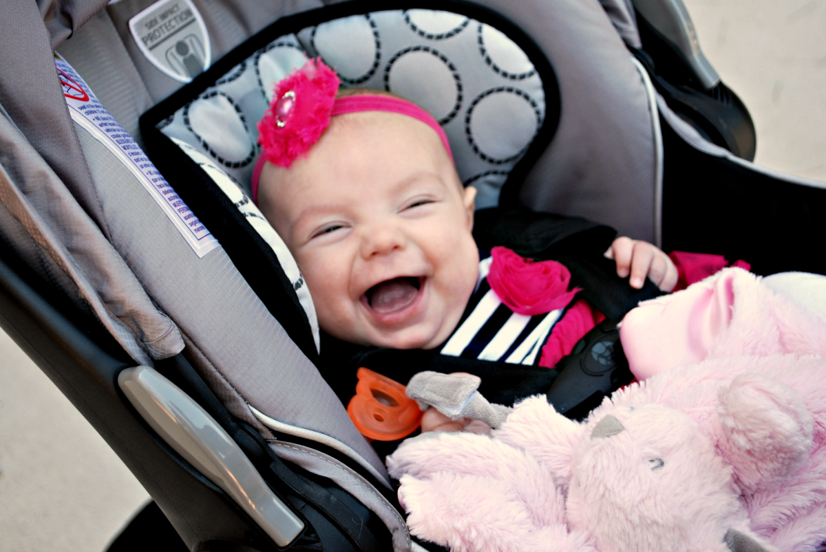 baby smiling and happy in car seat