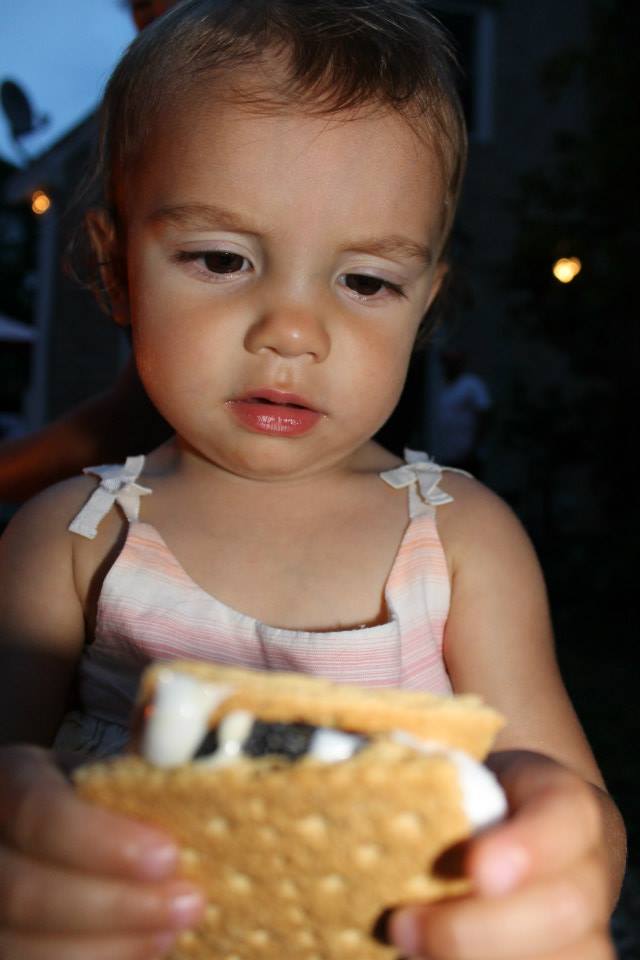 Toddler Making a funny face looking at smore