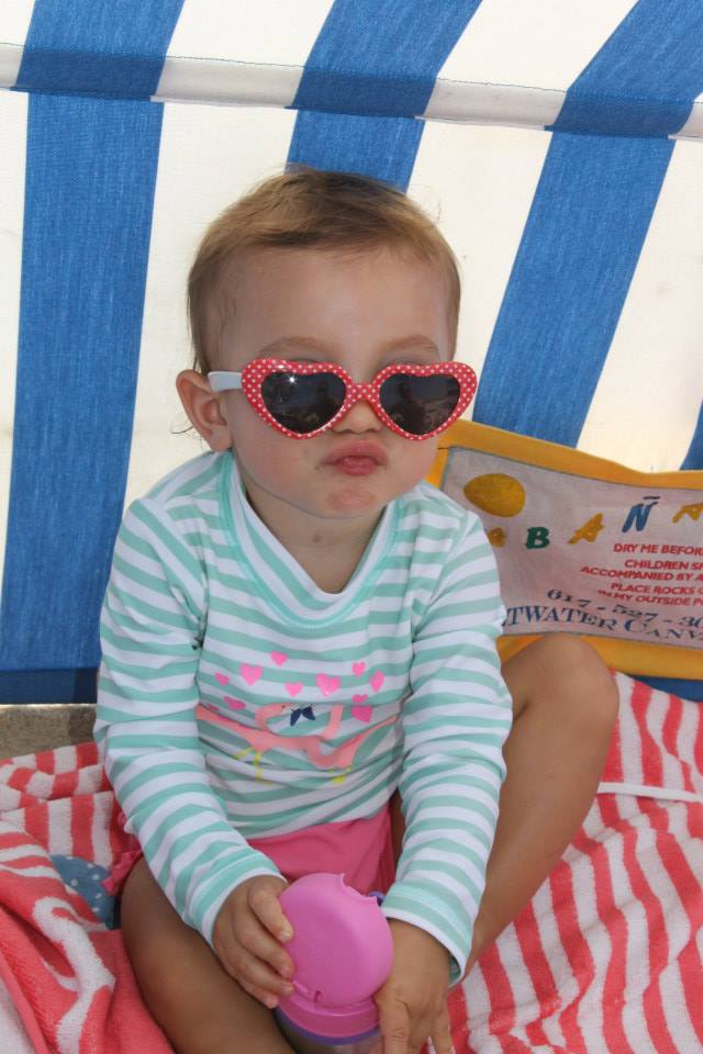 Toddler wearing heart shaped sunglasses making a silly face