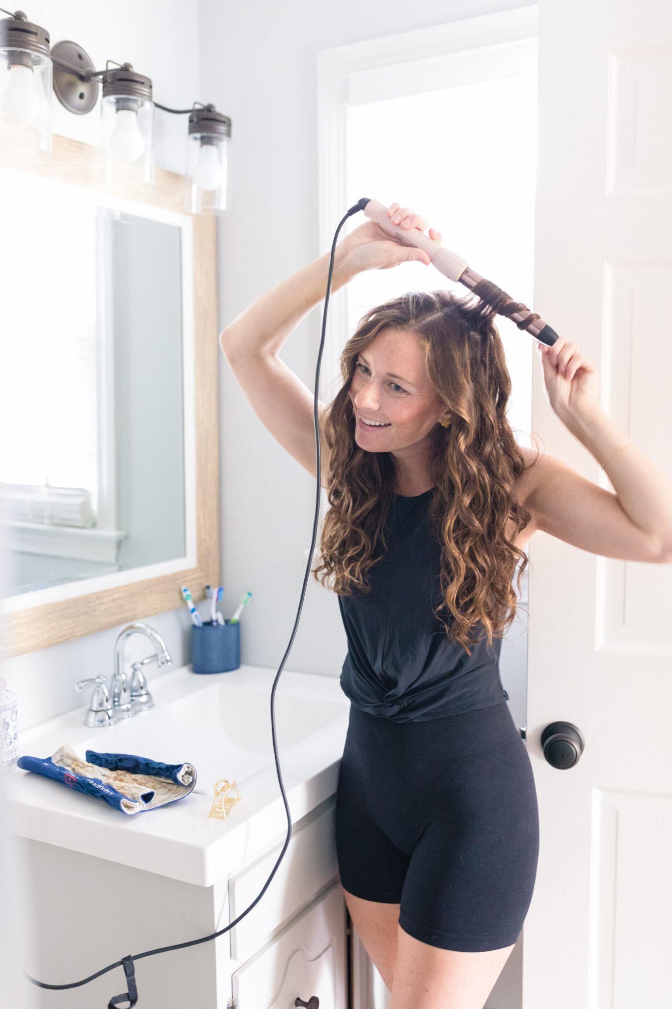 woman curling hair with wand