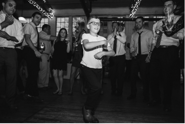 black and white photo little boy dancing at wedding