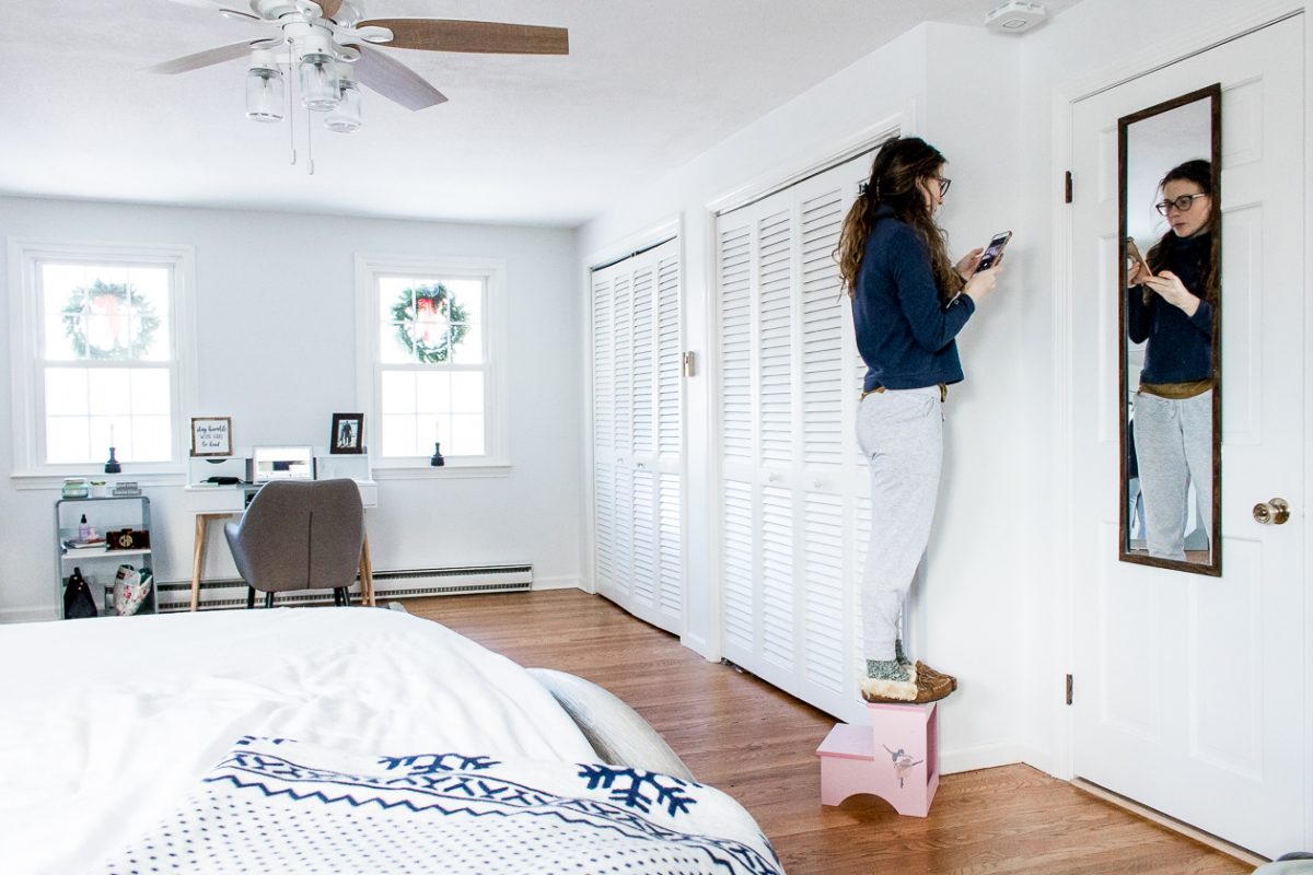 Woman Installing Fire Alarm on Ceiling in Bedroom - How to Keep Your Family Safe with Onelink Smart Smoke & Carbon Monoxide Alarm