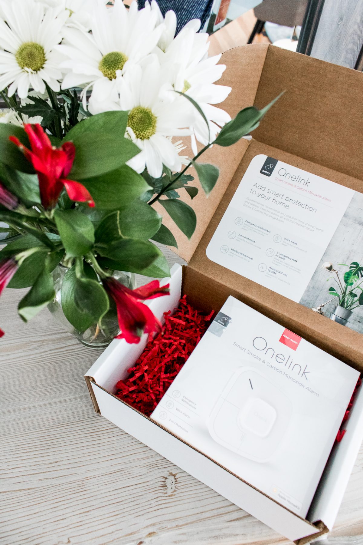 Overhead photo of Flowers and Onelink Smart Smoke & Carbon Monoxide Alarm in Box - How to Keep Your Family Safe with Onelink Smart Smoke & Carbon Monoxide Alarm