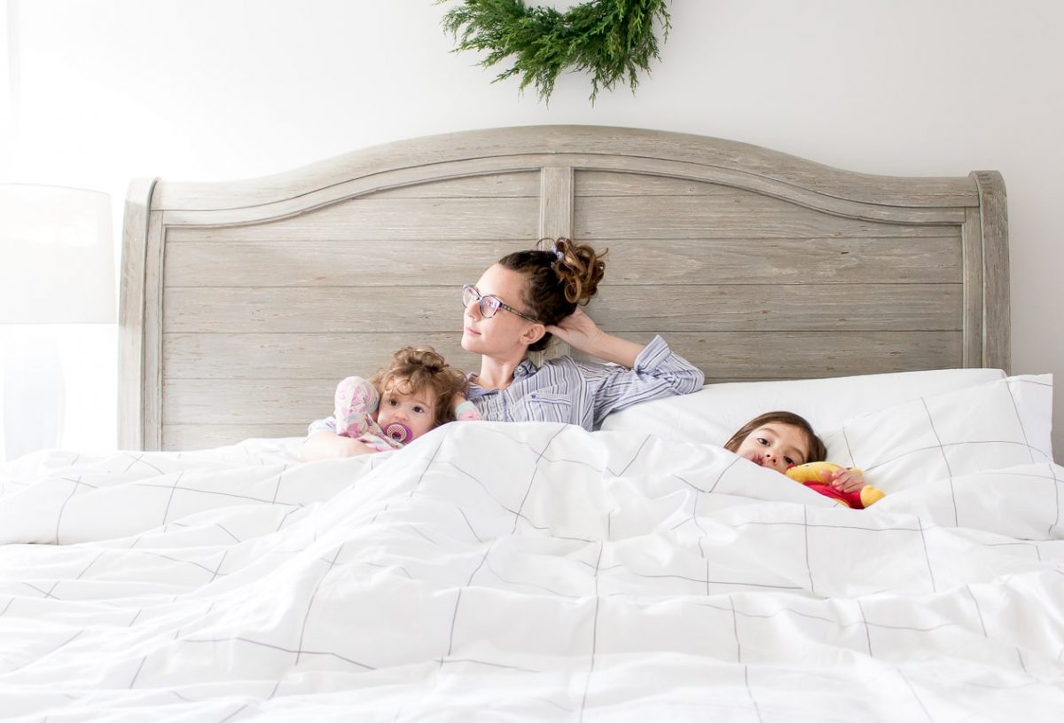 Mom in bed with little girls relaxing ready to sleep