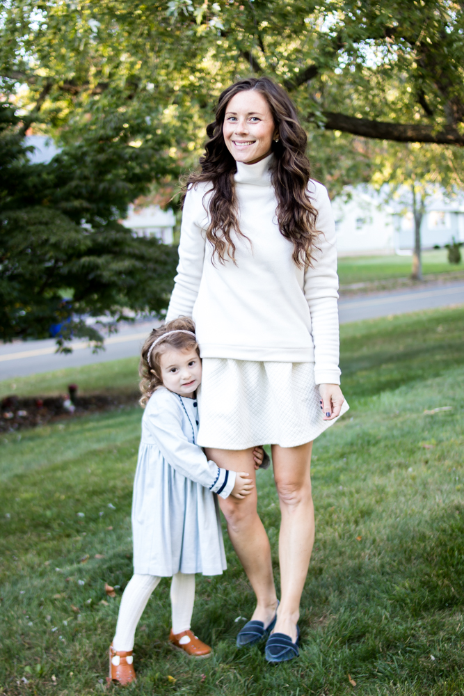 Mom and Daughter standing outside wearing white and blue outfits 
