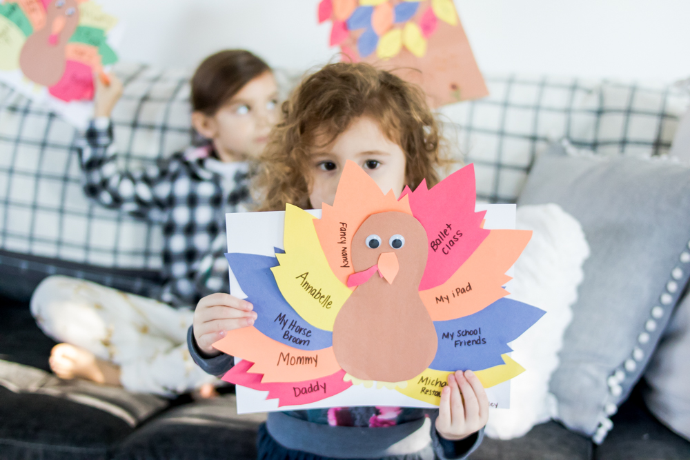 little girl holding a gratitude activity thankful turkey