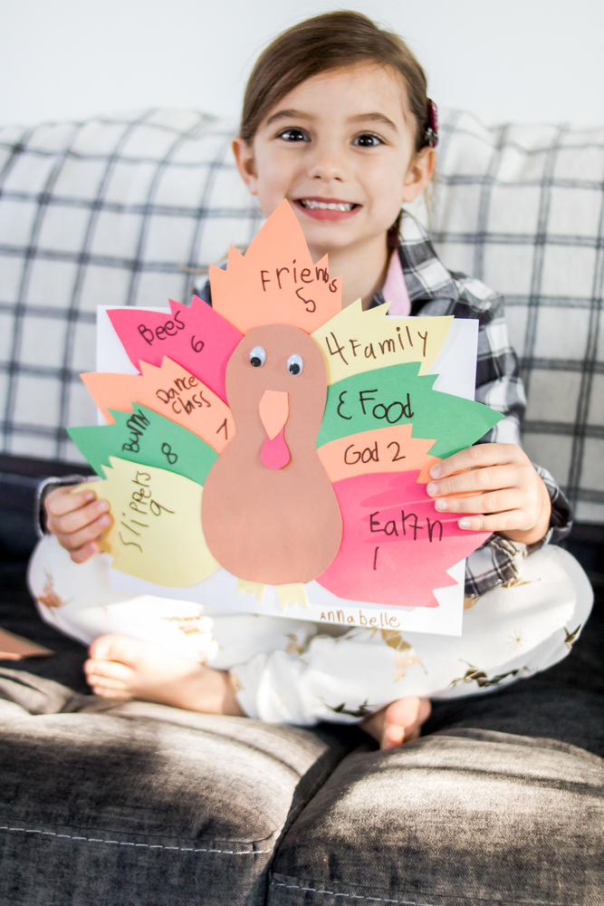 Little Girl Smiling and Holding a Handmade Thankful Turkey 