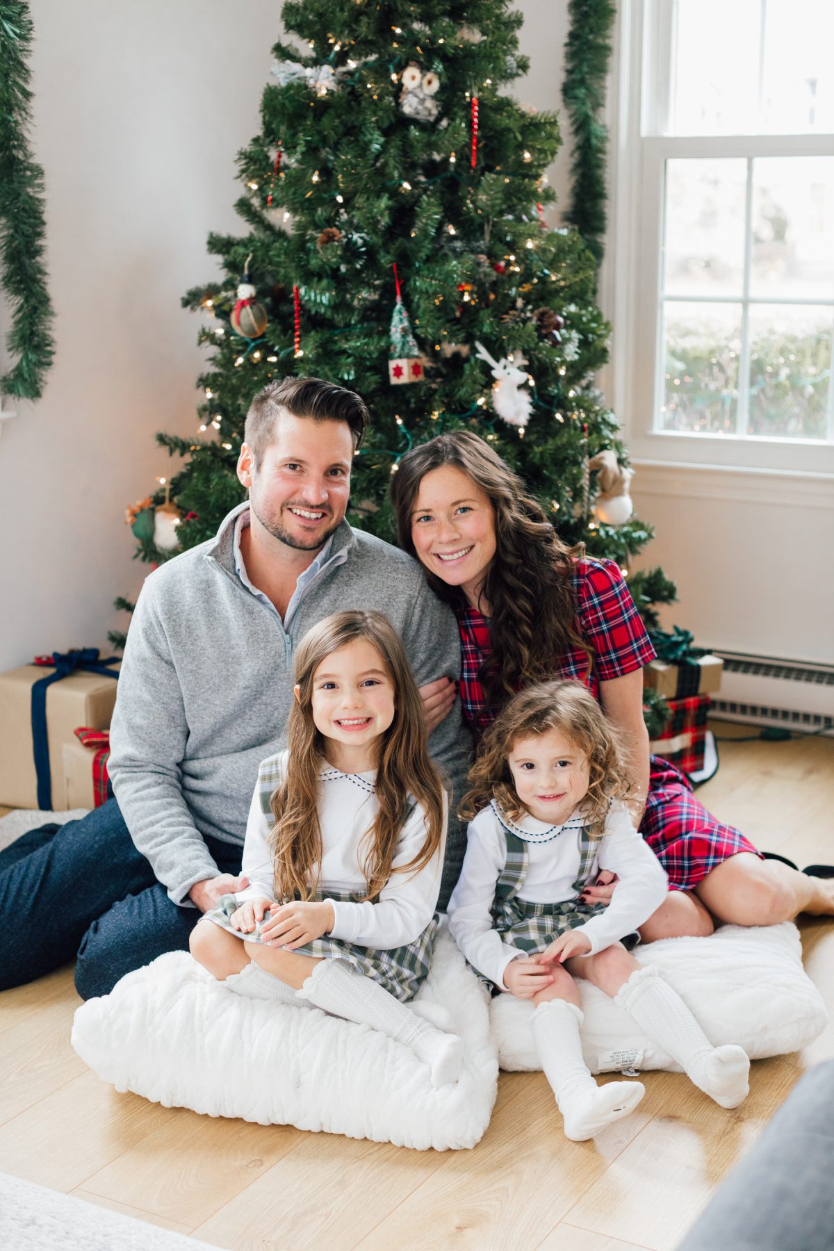 Family Photo in Front of Tree for Christmas Card wearing Red Plaid and Green Plaid