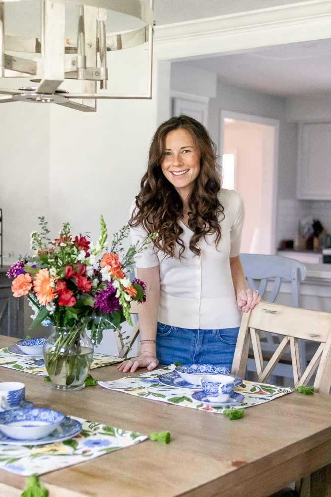 woman placing flowers on dining room table