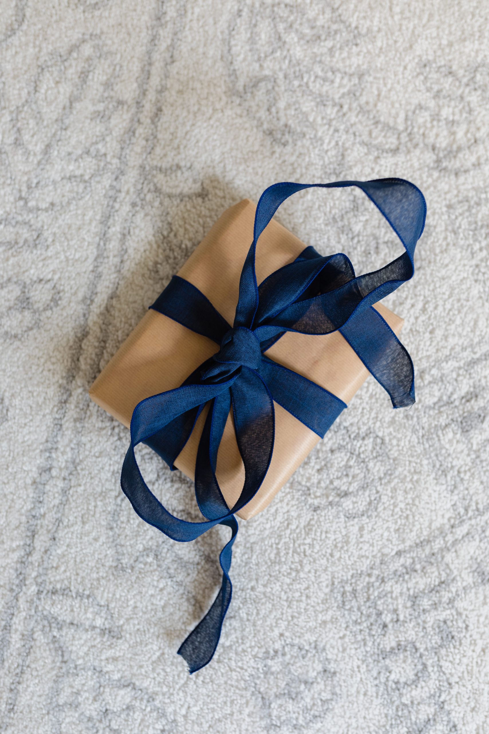 gift wrapped in brown paper with blue bow
