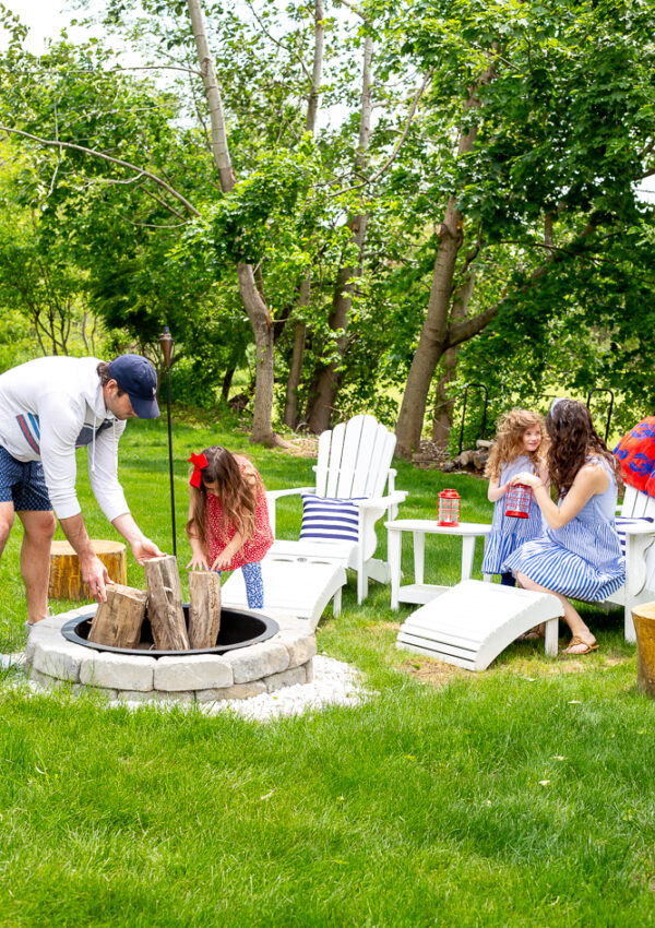 family decorating backyard and firepit area with red white and blue