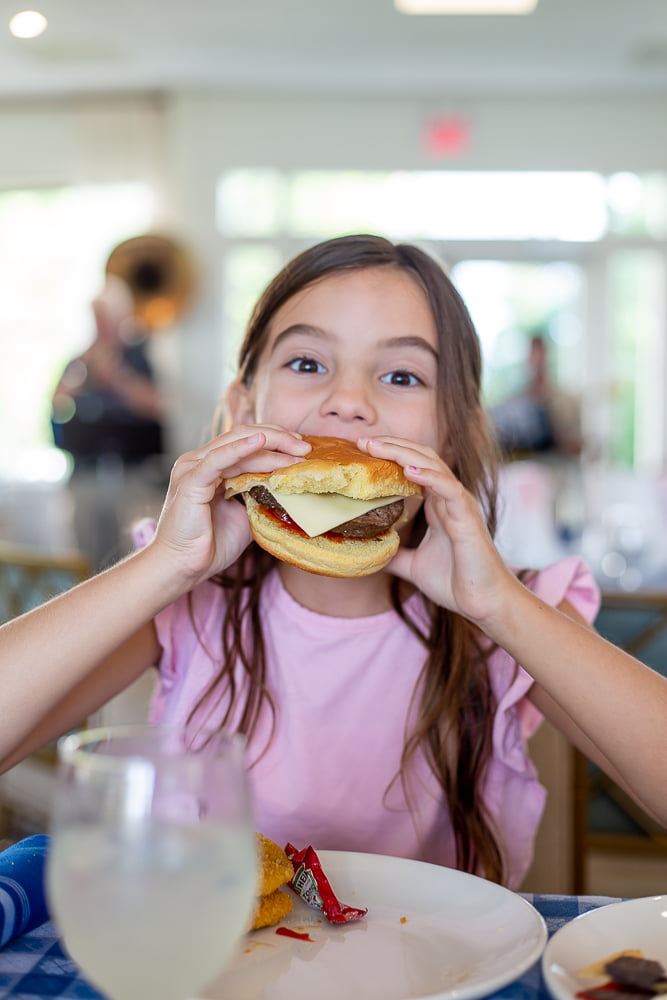 little girl eating cheeseburger