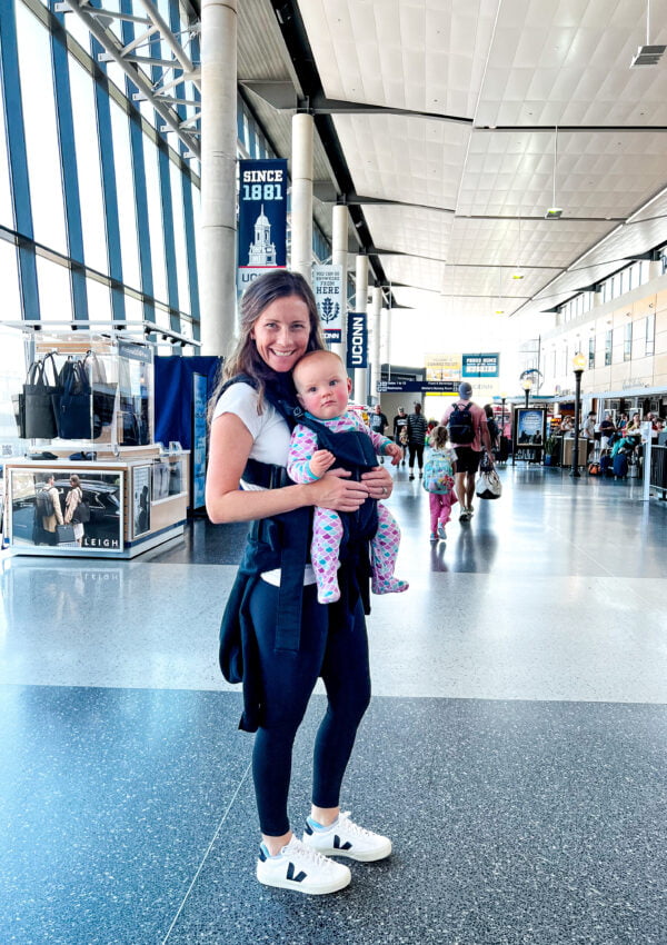 What to wear when flying with a baby - veja sneakers, leggings, baby carrier, tshirt