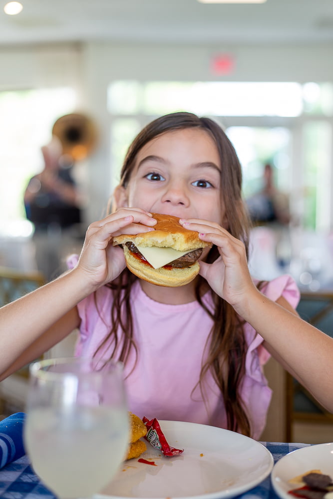 little girl eating cheeseburger basin harbor