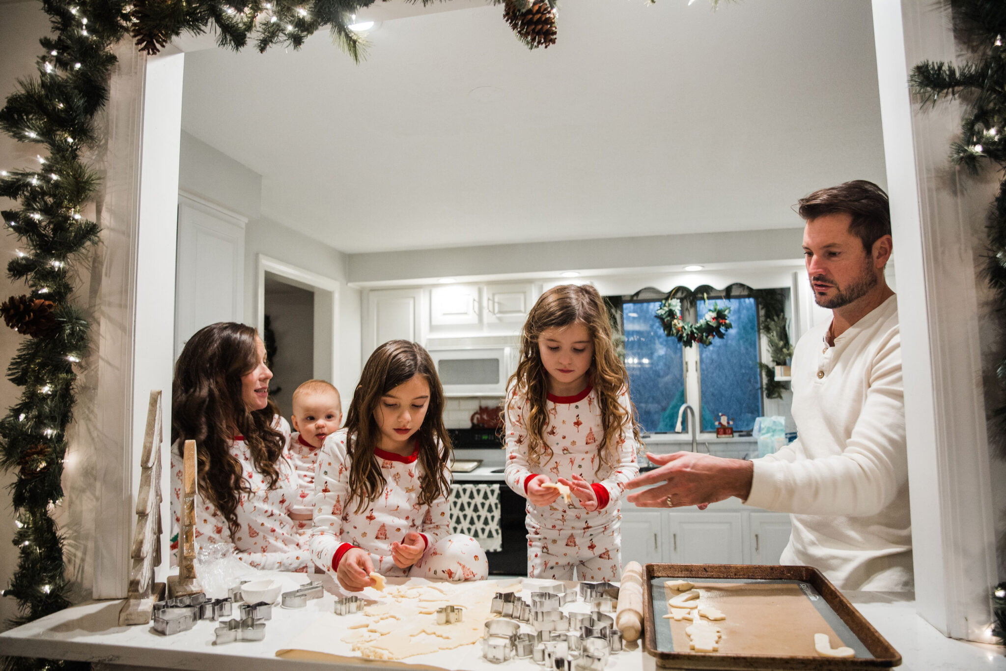 family baking christmas cookies in pajamas