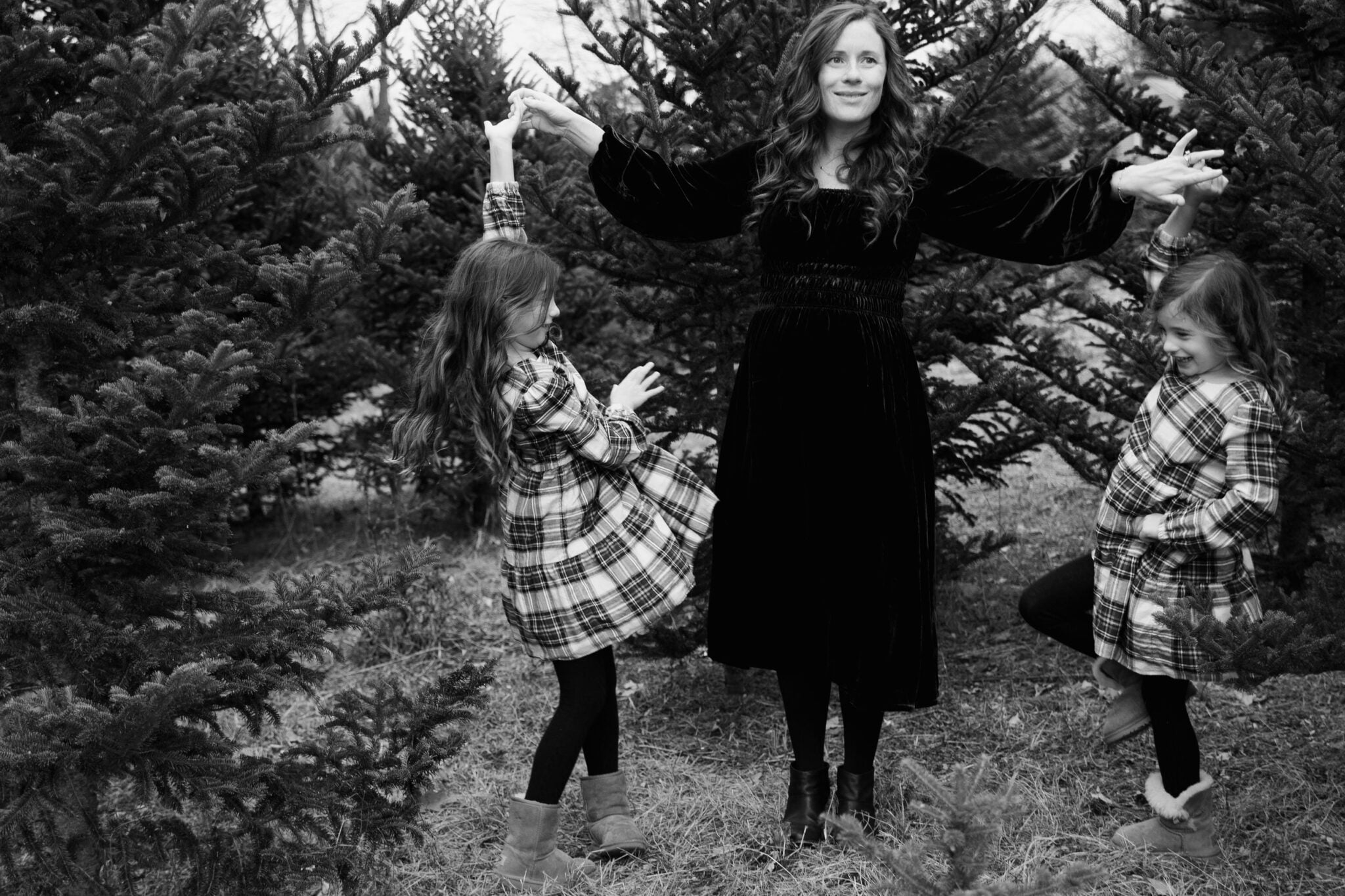 Mom dancing with daughters black and white photo christmas pictures tree farm
