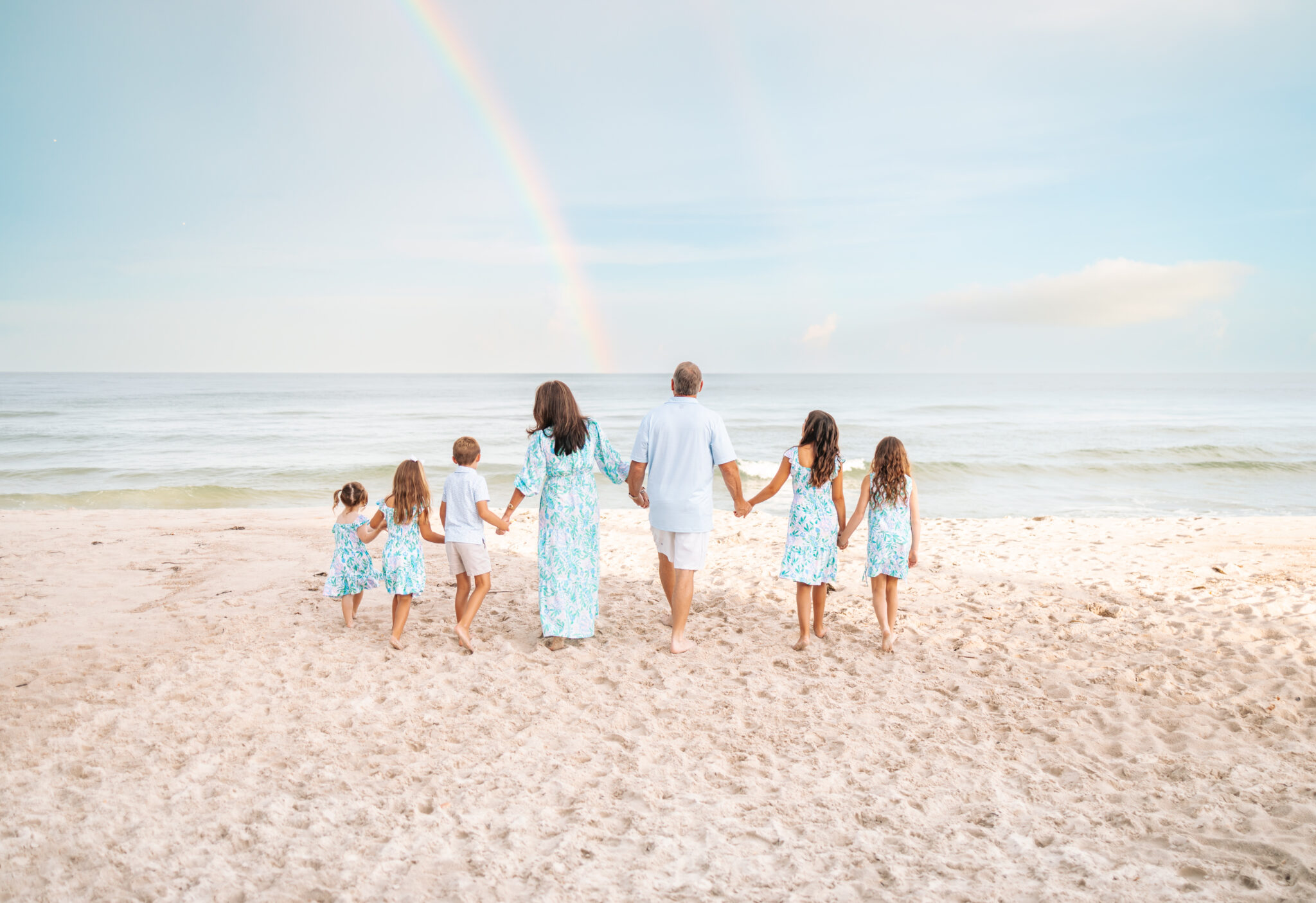 Grandparents and grandchildren walking towards ocean family photos at the beach in Lilly Pulitzer Just a Pinch print